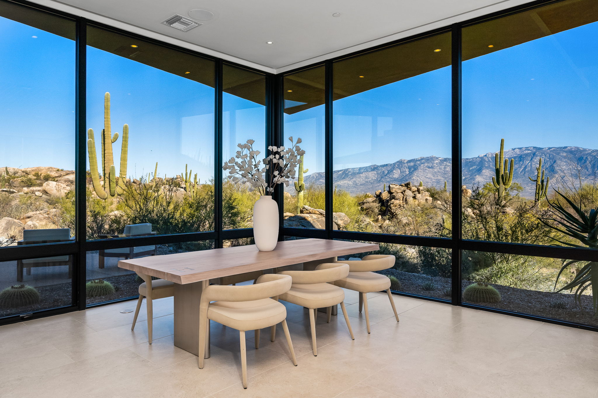 Dining room with floor-to-ceiling glass and saguaro and mountain views