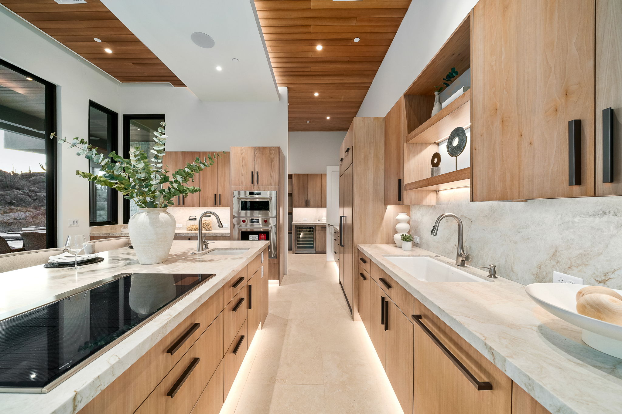 Modern kitchen with light wood cabinetry and stone countertops