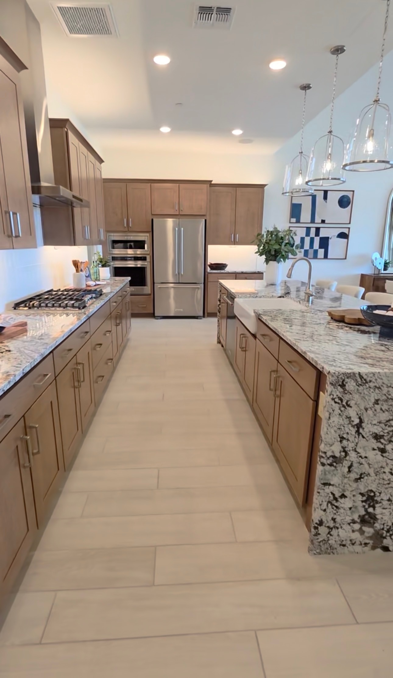 Kitchen with granite waterfall island and warm wood cabinetry in a Tucson area home